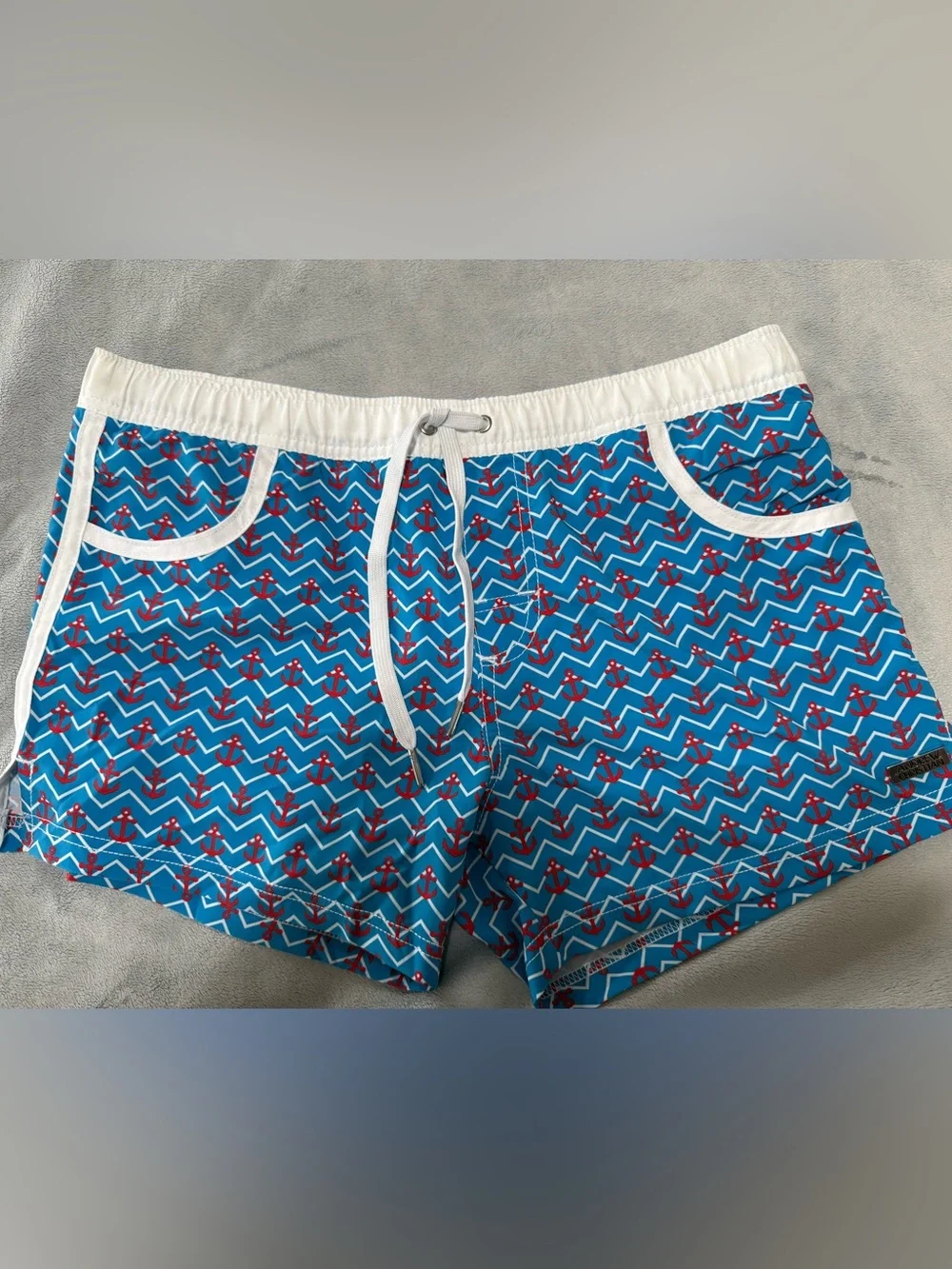 Andrew Christian blue, red and white lined swim trunks. Men’s size medium.